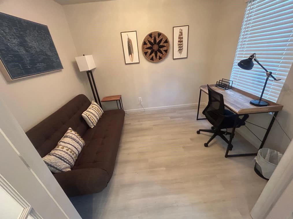 Home office corner with a sofa, desk and chair.